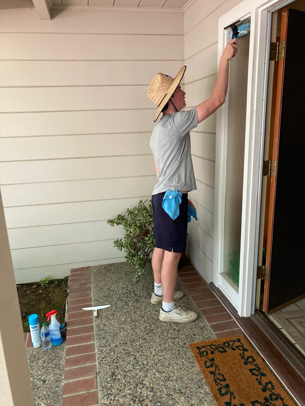 Technician cleaning a window with a squeegee